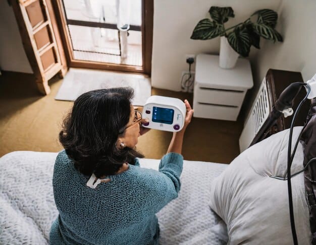A monitoring device is attached to a patient's arm while they are resting at home. Data from the device is being transmitted to a healthcare provider for remote monitoring.